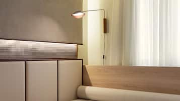 A modern room with a wooden sofa, a wall-mounted lamp, and a window with sheer curtains.