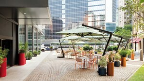 An outdoor patio with tables and chairs, surrounded by potted plants and umbrellas. - Duo Milan Porta Nuova, A Tribute Portfolio Hotel (Milan)