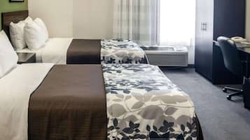 Habitación de hotel con dos camas, un escritorio y un equipo de aire acondicionado.
