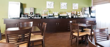 Un restaurante con mesas y sillas de madera, una barra con máquinas de café y decoración en las paredes.