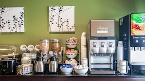 A coffee station with a daydream blend coffee machine, milk dispensers, and a juice dispenser. - Sleep Inn & Suites (Hagerstown)