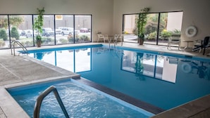 A swimming pool with clear water, a diving board, and a view of the street outside. - Sleep Inn & Suites (Hagerstown)