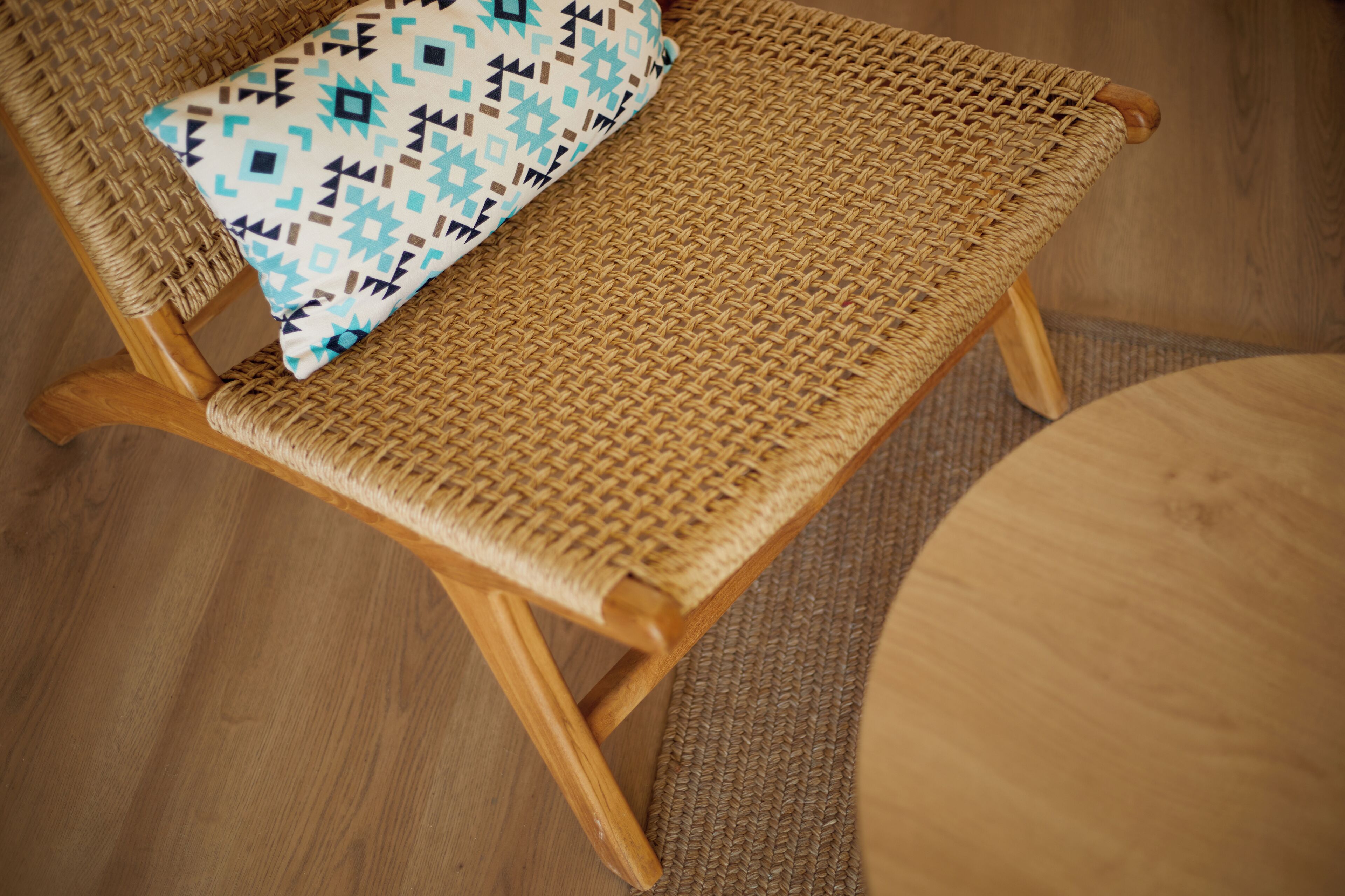 Une chaise en osier avec un coussin à motifs géométriques.
