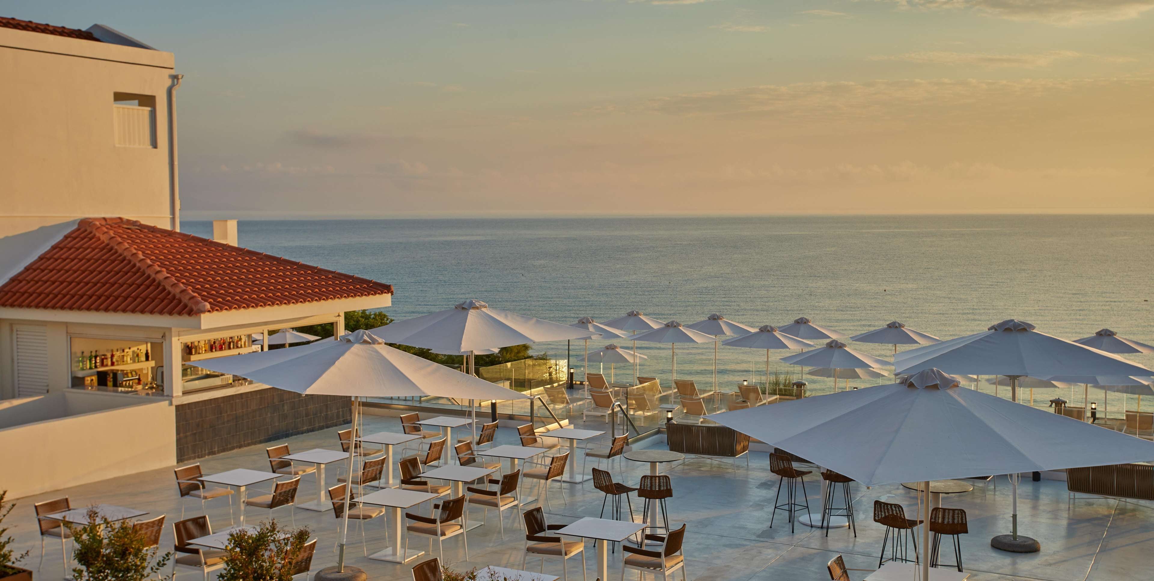 Una terraza en la azotea con mobiliario exterior y vistas al mar.