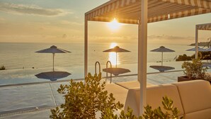 A poolside area with a pergola, lounge chairs, and umbrellas overlooking the sea. - AluaSoul Zakynthos - Adults Only - All Inclusive (Zakynthos)