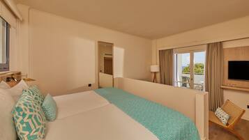Quarto de hotel com uma cama grande, televisão na parede e vista para o exterior pela janela.
