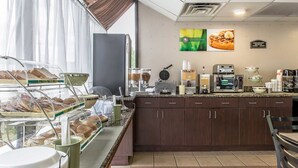 A breakfast bar with various food items and a coffee station. - Quality Inn Montgomery South (Montgomery)