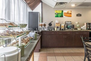 Una barra de desayuno con diversas opciones de comida y una estación de café.
