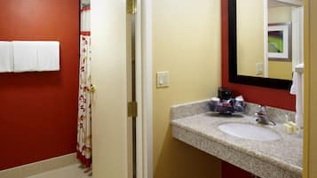 Un baño con lavamanos, espejo y paredes rojas.