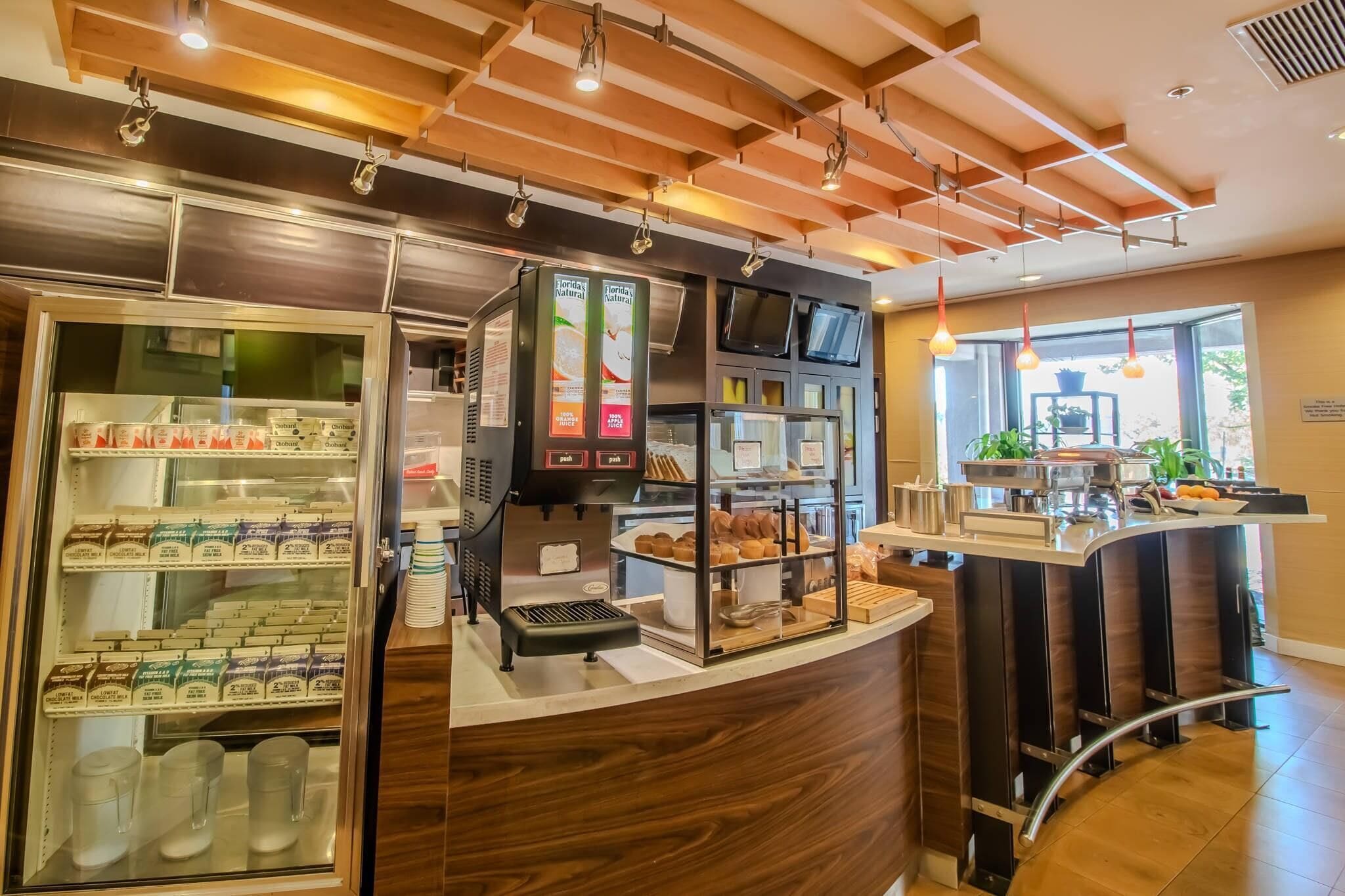Un comptoir de boulangerie avec une machine à café, un présentoir réfrigéré et une vue sur la rue.