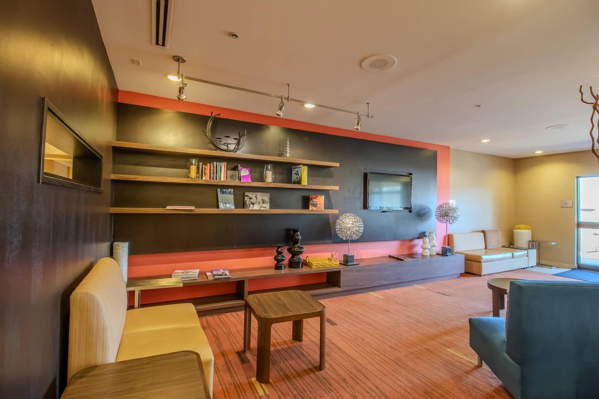 A modern living room with a sofa, a coffee table, and a TV mounted on the wall.