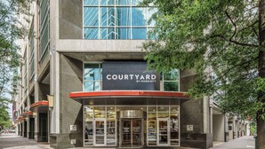 Un edificio moderno con un letrero que dice "COURTYARD BY MARRIOTT" y una puerta giratoria.
