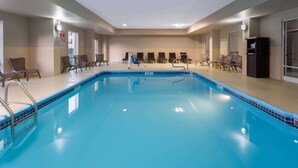 Una piscina con sillas de descanso y un vestuario.