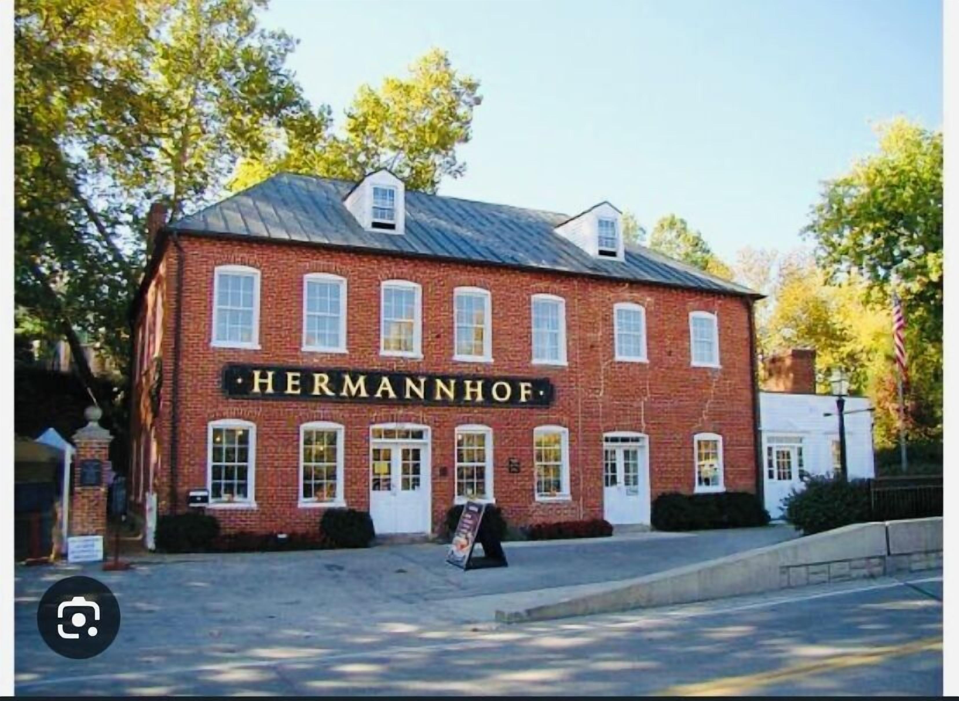 Un bâtiment en briques avec une enseigne portant l’inscription « HERMANNHOF » sur la façade.