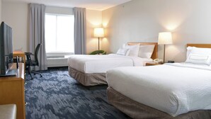 A hotel room with two beds, a desk with a computer, a chair, and a TV.