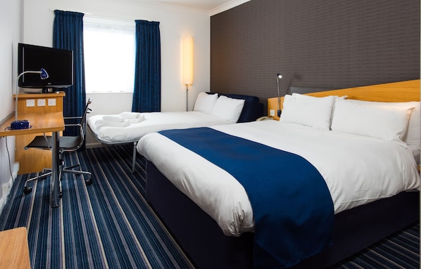 A hotel room with two beds, a desk with a computer, a television, and a window with curtains. - Holiday Inn Express Southampton - West by IHG (Southampton)