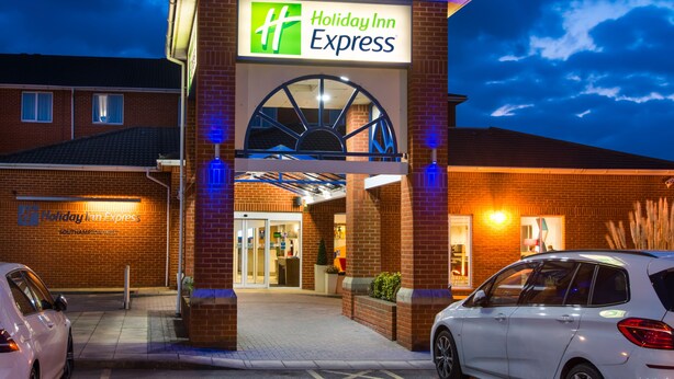 A Holiday Inn Express building with a clear entrance, a parking area, and a visible sign. - Holiday Inn Express Southampton - West by IHG (Southampton)