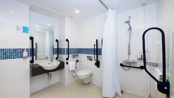 Un baño moderno con lavamanos, inodoro y ducha blancos.