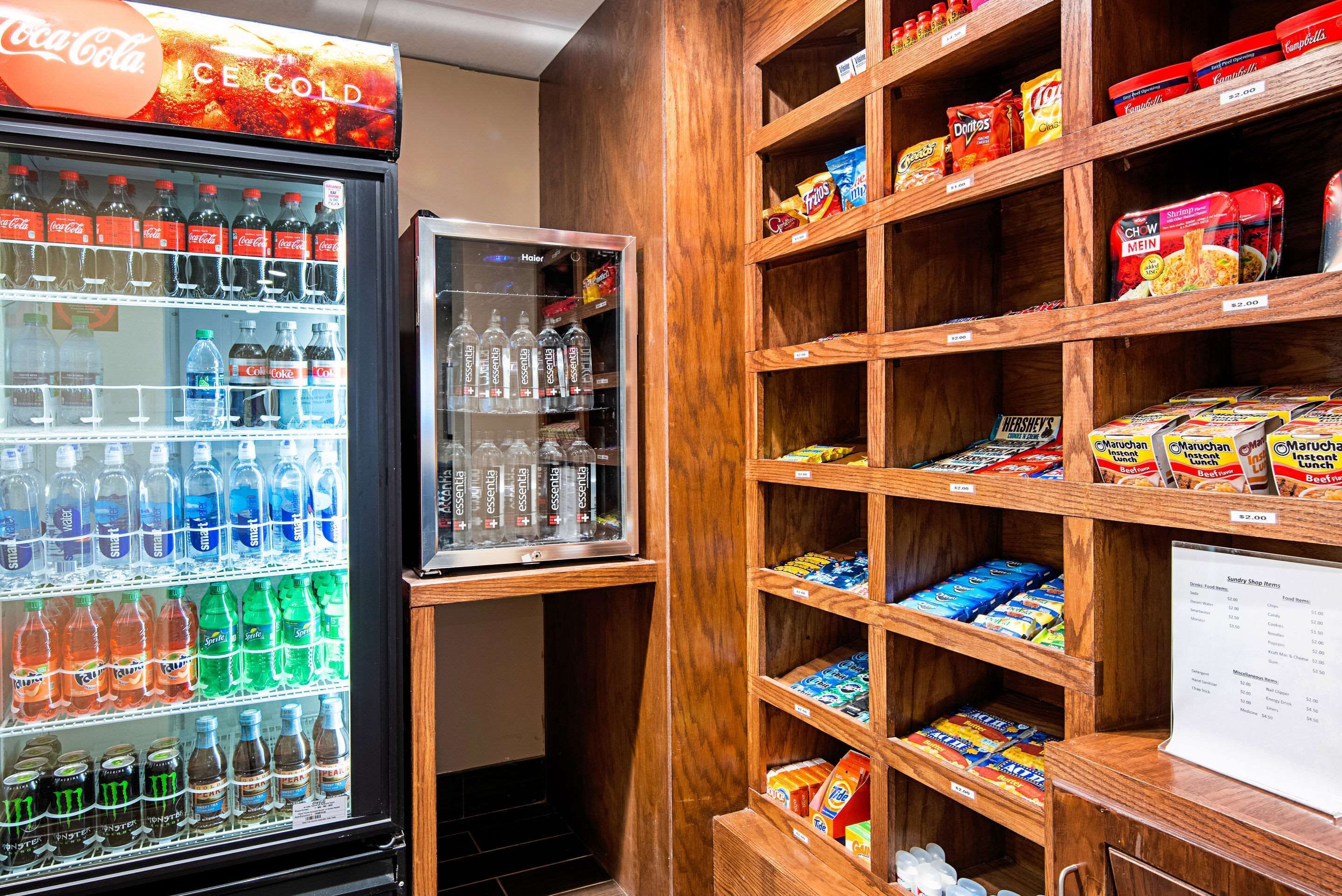 A vending machine stocked with various drinks and snacks, including Coca-Cola and Doritos, in a wooden display area.
