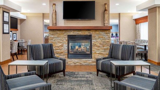A modern lobby with a stone fireplace, comfortable seating, and a flat-screen TV mounted above. - Hampton Inn Mitchell (Mitchell)