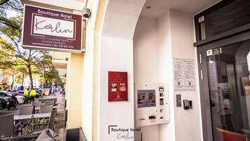 L'ingresso di un hotel con una insegna che riporta "Boutique Hotel Berlin" e un codice QR per il check-in.