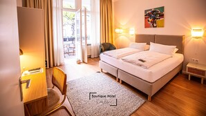 A hotel room with a bed, desk, chair, and a view of the outdoors. - Boutique Hotel Kerlin (Berlin)
