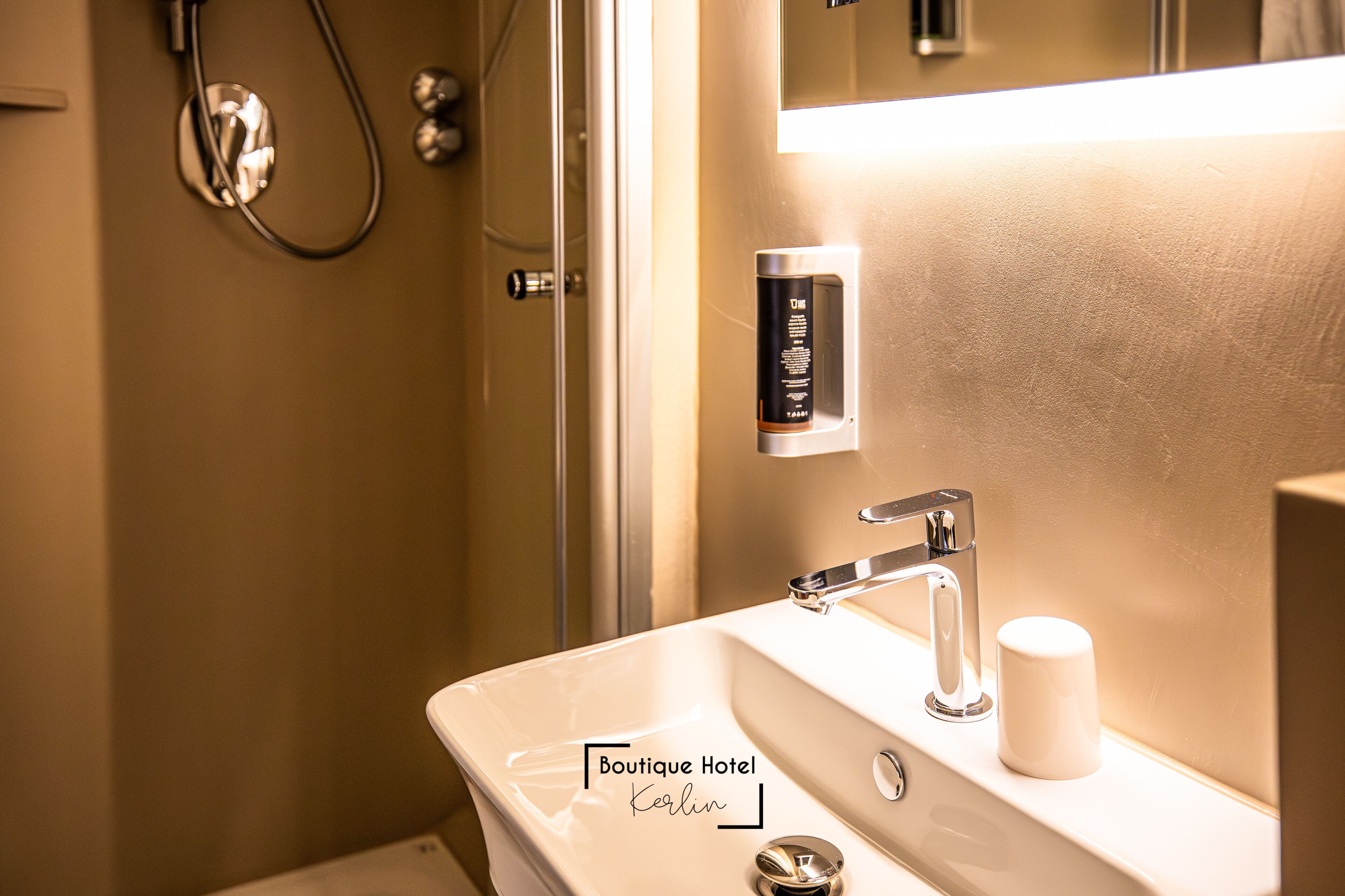 A bathroom with a white sink, a mirror, and a shower.