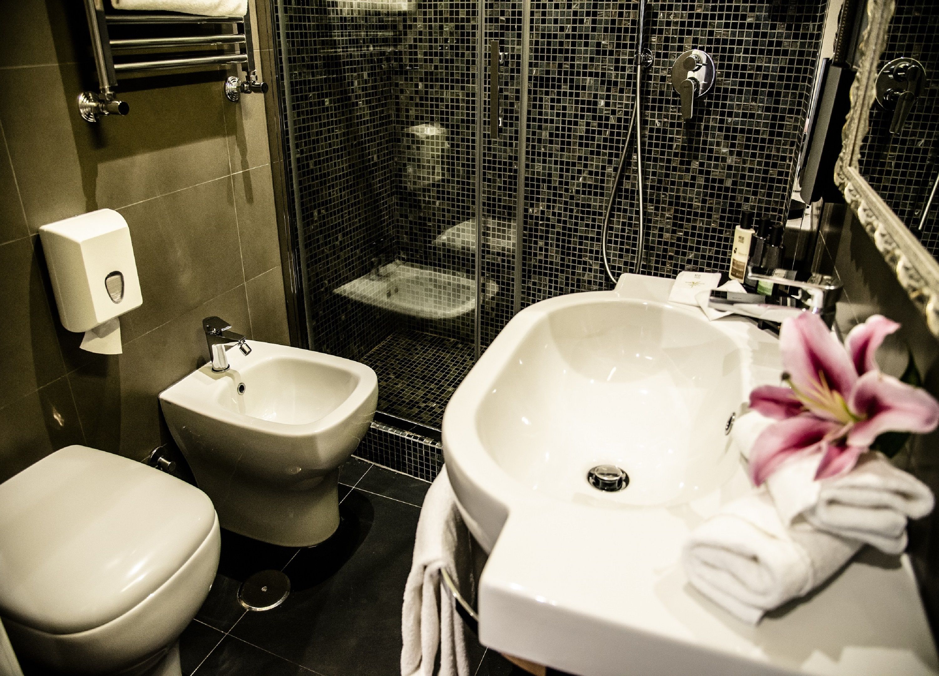 A bathroom with a bidet, toilet, and sink.