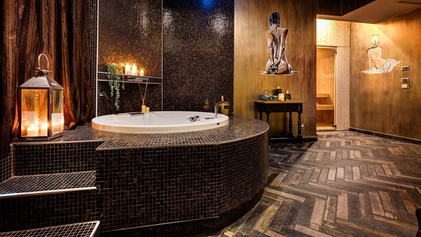Une salle de bain moderne avec une baignoire sur pieds, un plancher en bois et un grand miroir.