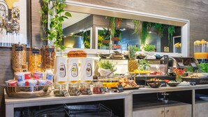 Un buffet proposant une variété de plats, notamment des fruits, des pâtisseries et des condiments.