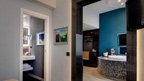 Une salle de bain moderne avec un meuble-lavabo, un espace douche et un lavabo orné de mosaïques.