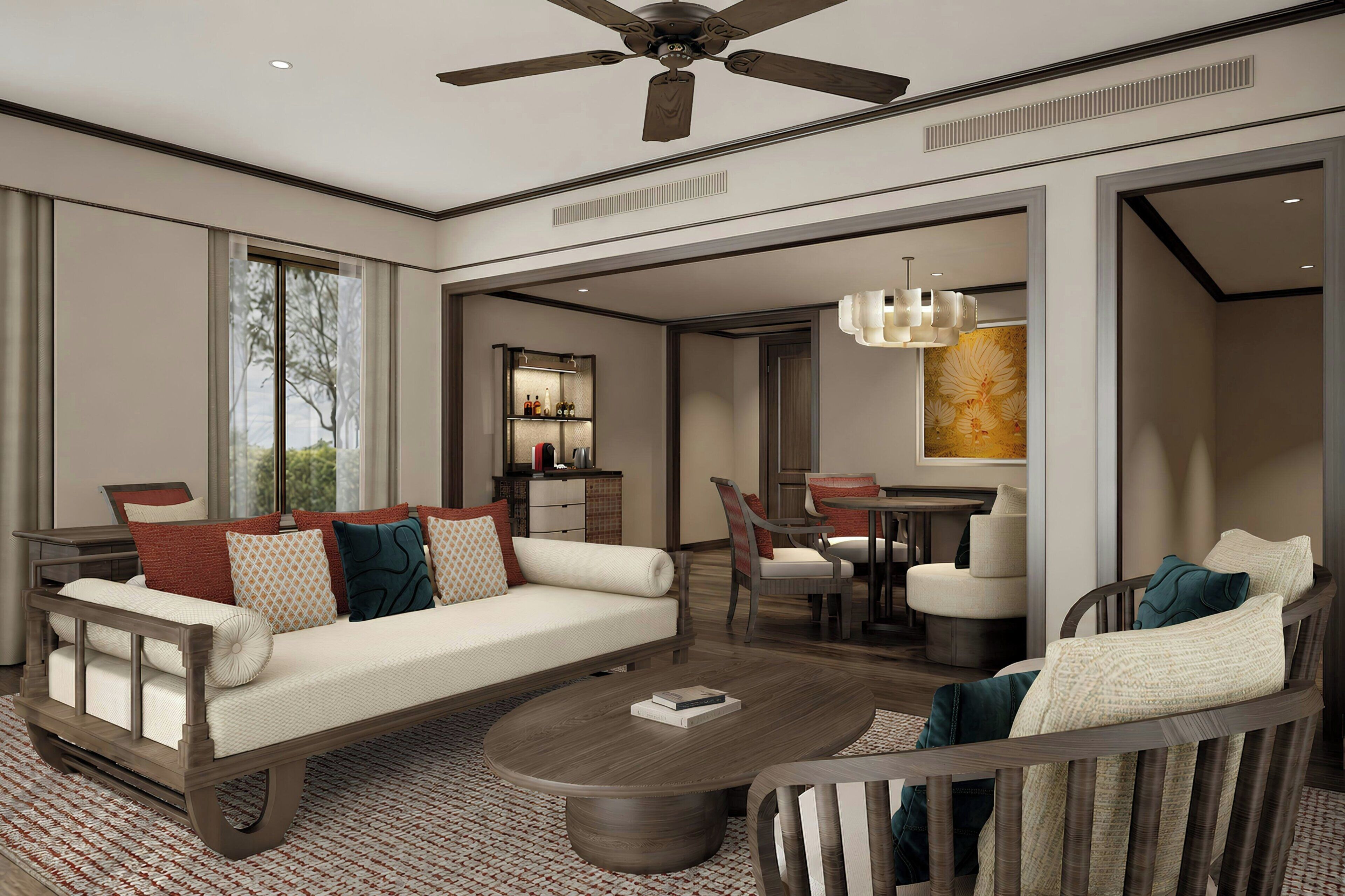 A spacious living area with a sofa, chairs, a coffee table, and a ceiling fan.