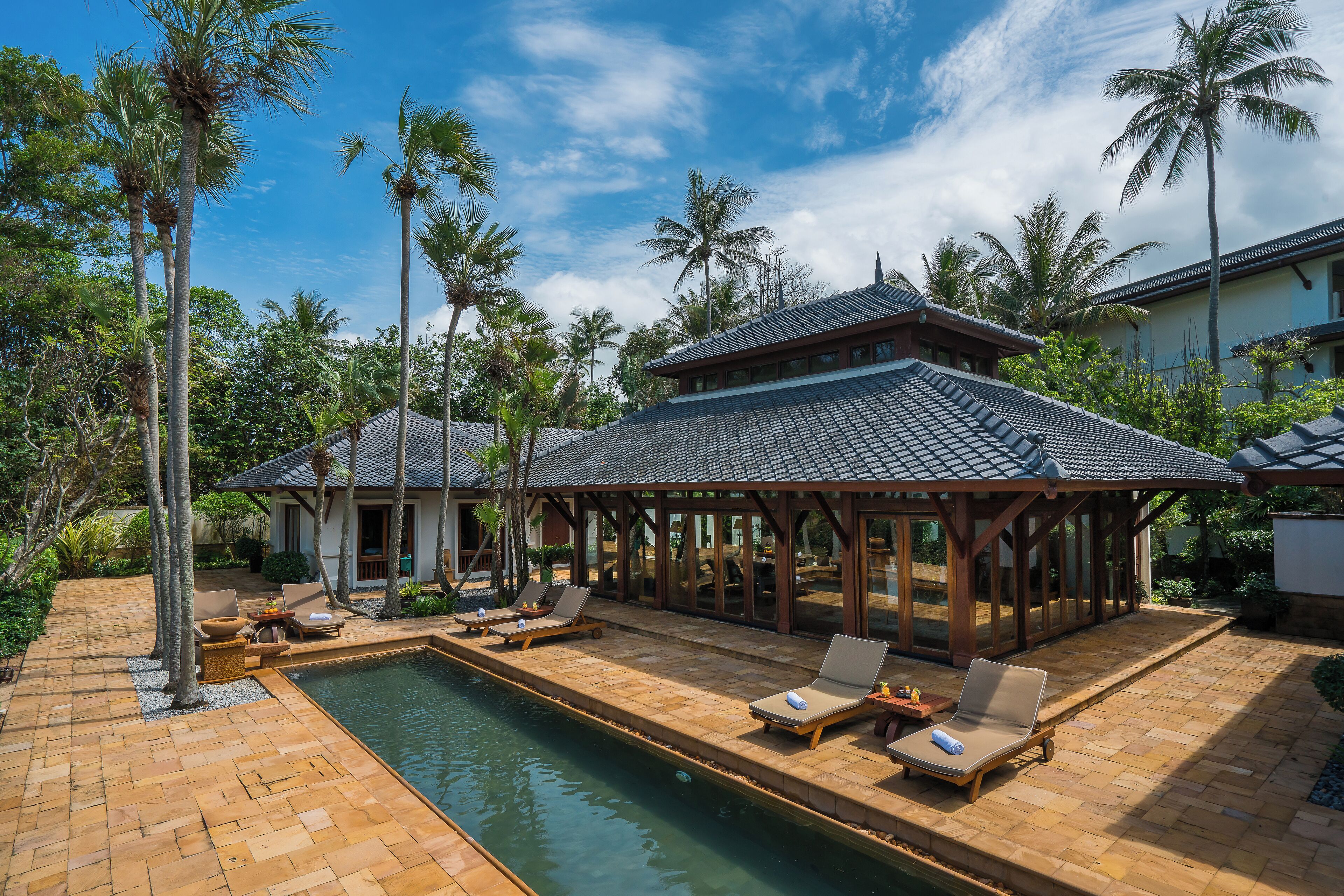 A poolside area with lounge chairs and a covered pavilion.