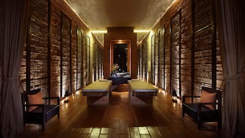 Guests can relax on benches lining the corridor, leading to a central area with a sink and mirror.