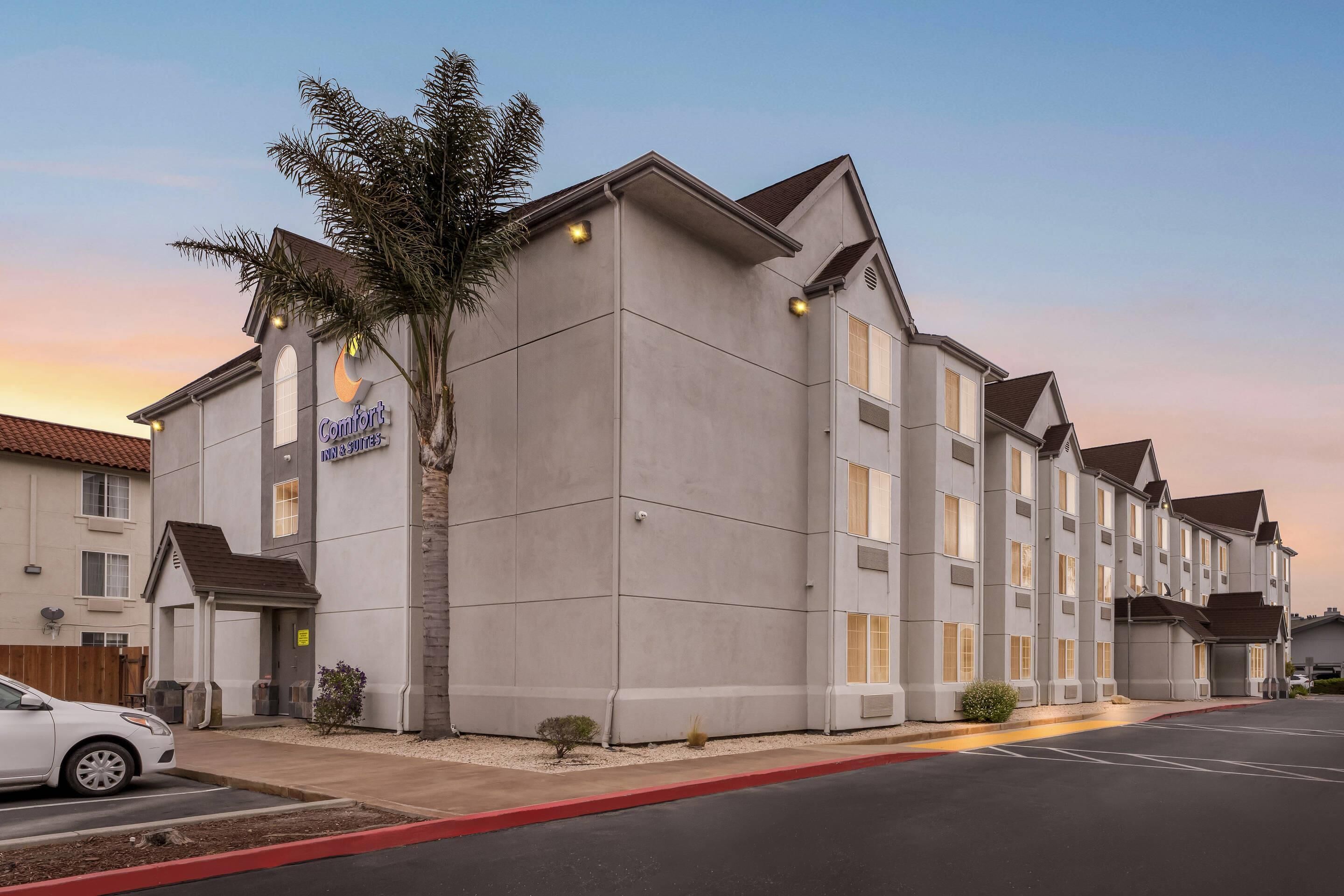 A multi-story hotel with a modern design, featuring a prominent sign for 'Comfort Suites'.