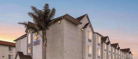 A multi-story hotel with a modern design, featuring a prominent sign for 'Comfort Suites'.