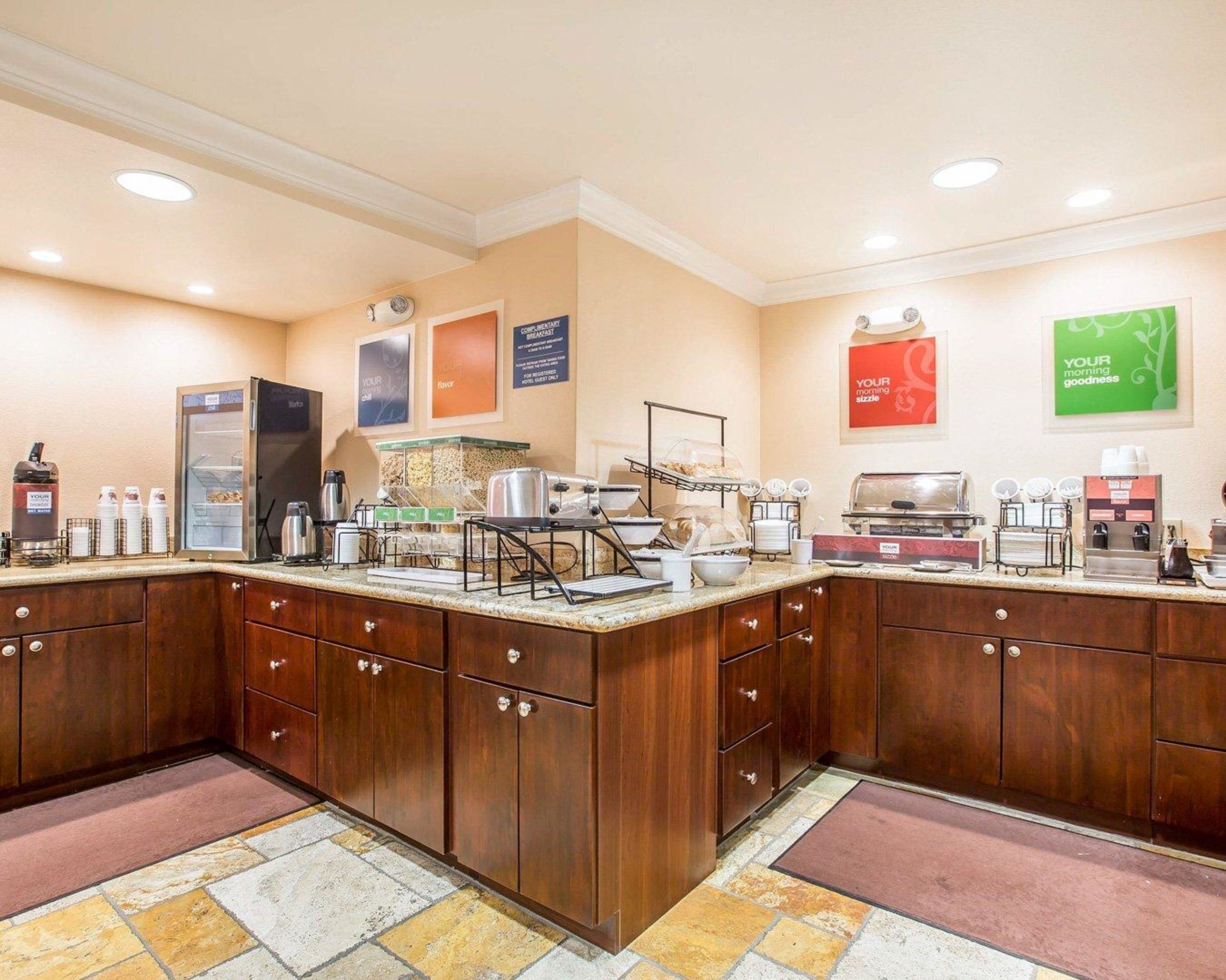 A breakfast bar with a refrigerator, coffee machines, and a buffet setup.