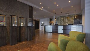 Un interior moderno con suelo de madera, una recepción y una zona de cocina.