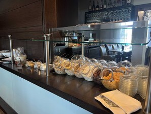 Un área de bufé con diferentes opciones de comida y utensilios.