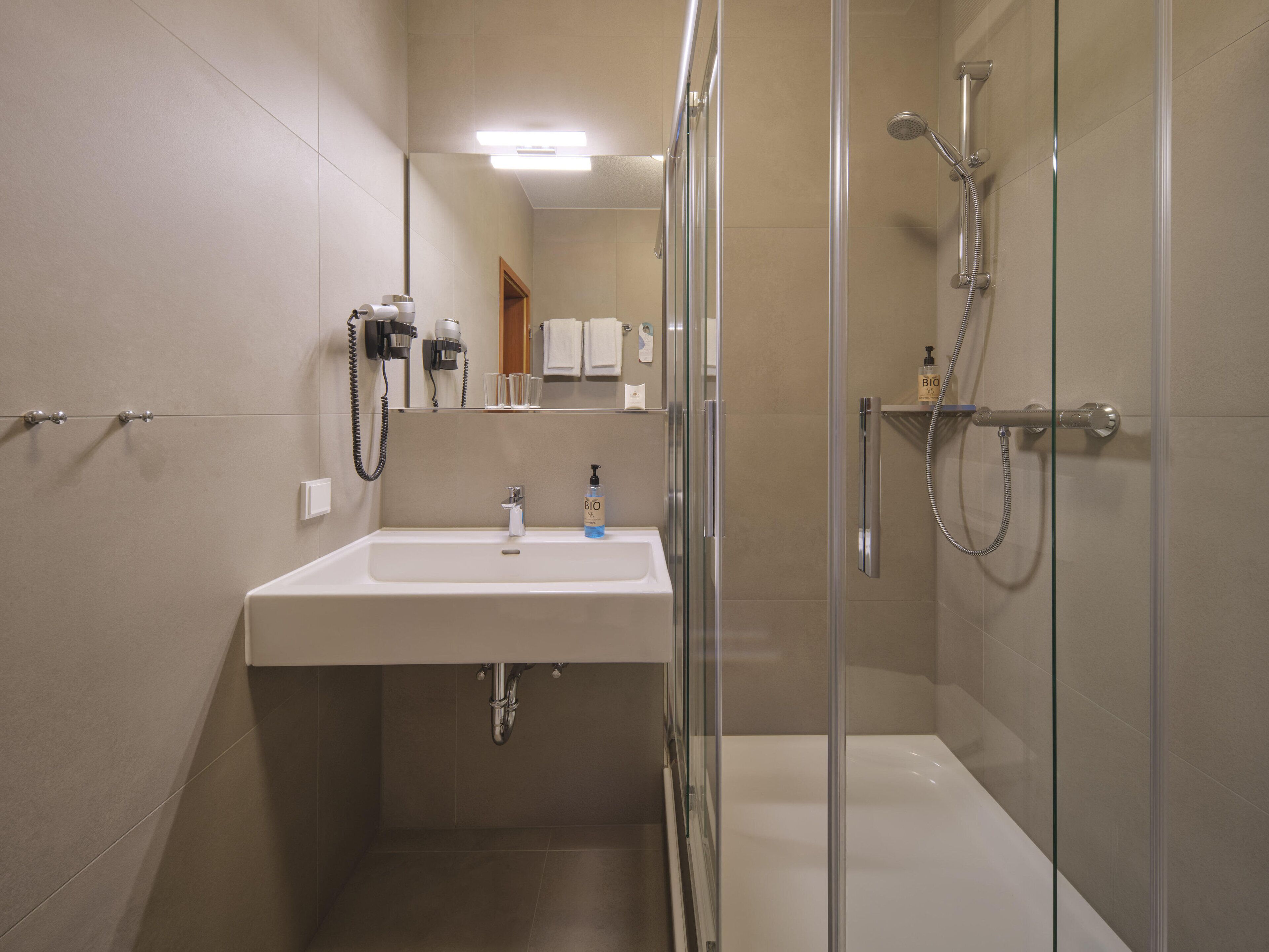 standard single room | bathroom | shower, eco-friendly toiletries, hair dryer, towels