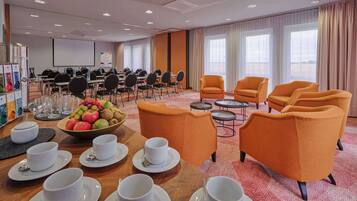 A conference room with tables, chairs, and a fruit bowl.