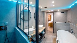 A modern bathroom with a glass shower enclosure, a large bathtub, and a vanity with a sink. - Best Western Plus Opera Batignolles (Paris)