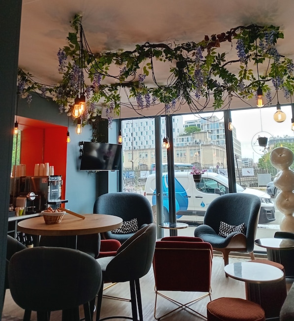 Un accogliente caffè dall'arredamento moderno, con schermo piatto, posti a sedere confortevoli e vista sulla città grazie a ampie finestre.