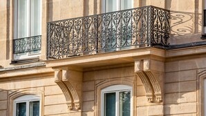 A building facade with ornate wrought iron balcony railings and classical architectural details. - Best Western Plus Opera Batignolles (Paris)