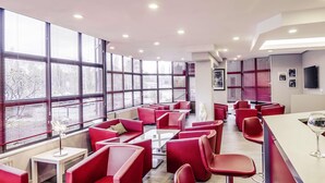 Un restaurante moderno con asientos rojos, ventanas amplias y un televisor de pantalla plana.
