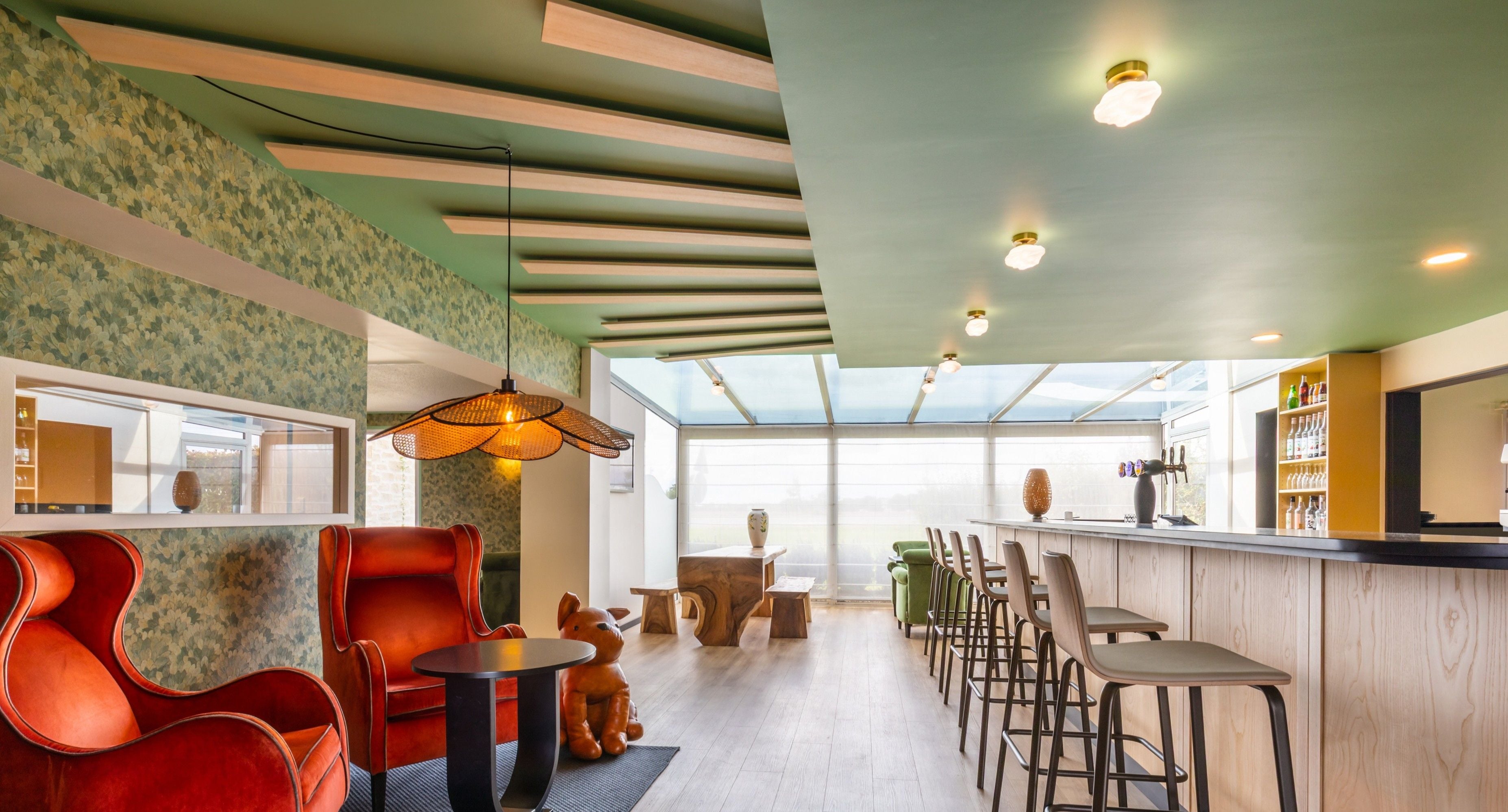 A modern hotel interior with a bar area, seating, and a view through large windows.