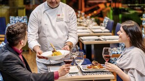 A restaurant setting with a waiter serving food to diners. - Mercure Sao Paulo Moema Hotel (São Paulo)