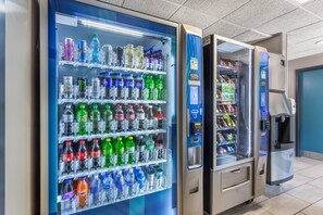 Una hilera de máquinas expendedoras de bebidas con diversas opciones.