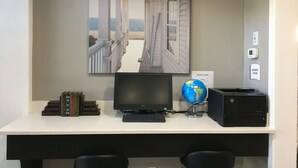 Un escritorio con una computadora, un globo terráqueo y libros.