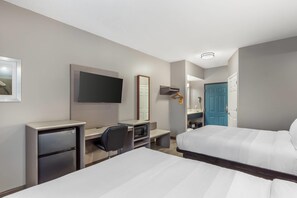 A hotel room with two beds, a desk with a chair, a microwave, a refrigerator, a TV, and a wardrobe. - Quality Inn Wilmington (Wilmington)